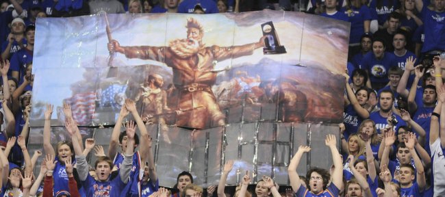 The Jayhawk student section displays an enlarged and modified version of artist John Steuart Curry's "Tragic Prelude" painting, which features abolitionist John Brown holding a rifle, and in this case the 2008 National Championship trophy.
