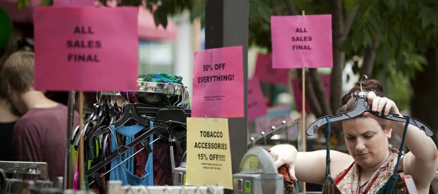 Above, Lawrence resident Emily Bayouth searches through a rack of dresses outside Creation Station during the 2009 Downtown Lawrence Sidewalk Sale.