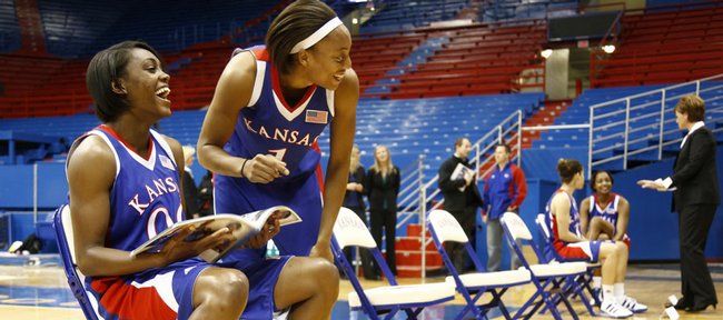 Kansas University teammates LaChelda Jacobs and Aishah Sutherland share a laugh as they browse the media guide on Wednesday in Allen Fieldhouse.