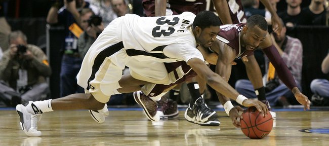 Purdue's E'Twaun Moore (33) and Texas A&M's Dash Harris dive for a loose ball as Texas A&M's Bryan Davis looks on at top in the final seconds of the second half of an NCAA second-round college basketball game in Spokane, Wash., Sunday, March 21, 2010. Purdue beat Texas A&M 63-61 in overtime.