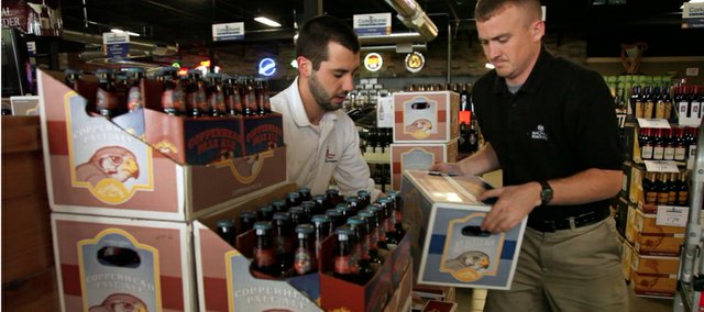 Mike Schard and Kyle Case of Standard Beverage Corporation of Lawrence unload and stack the first cases of bottled beer from Free State Brewing Company at Cork and Barrel, 23rd and Iowa streets. The local microbrewery first started trying to bottle beer two years ago and has finally reached the point where it can supply stores in Lawrence. Liquor stores in Topeka, the Kansas side of Kansas City and Wichita should start seeing the beer in the next month.