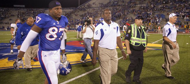 Head coach Turner Gill purses his lips as he makes his way from the field alongside tight end Bradley Dedeaux (87) and defensive coordinator Carl Torbush following the Jayhawks' 6-3 loss to North Dakota State, Saturday, Sept. 4, 2010 at Kivisto Field.