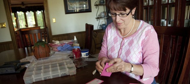 Tammy Frank, Lawrence resident and creator of Lobes of Love, works Tuesday evening assembling packages of earrings that she will be delivering to the oncology ward at KU Cancer Center. Frank says that her inspiration for the project is her mother, Karen Johnson, Fort Scott, who is currently battling breast cancer.