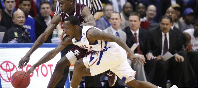Kansas guard Tyshawn Taylor knocks the ball away from Texas A&M forward Naji Hibbert during the first half on Wednesday, March 2, 2011 at Allen Fieldhouse.