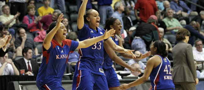 Kansas University’s Tania Jackson (33), Natalie Knight (42), and other team members celebrate their 70-64 victory over Delaware in a second-round NCAA Tournament game on Tuesday in Little Rock, Ark. The Jayhawks advanced to the Sweet 16 for the first time since 1998.