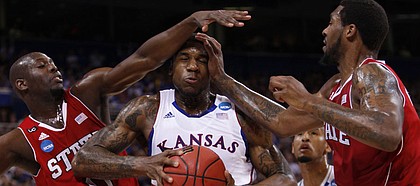 Kansas forward Thomas Robinson gets some contact from North Carolina State forwards DeShaun Painter (0) and Richard Howell during the first half on Friday, March 23, 2012 at the Edward Jones Dome in St. Louis.