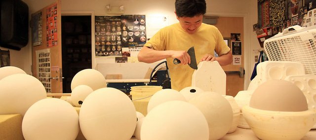 Allen Chen separates a mold for an installation Monday at the Lawrence Arts Center. Chen is a ceramics artist and a Lawrence Arts Center artist in residence. The year-long residency program chooses artists who can create a new body of work as well as contribute to the community during their time in Lawrence.
