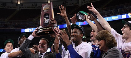 Kansas players crowd around head coach as they are presented with the Midwest Regional trophy as they celebrate the Jayhawks' 80-67 win over North Carolina to advance to the Final Four on Sunday, March 25, 2012 at the Edward Jones Dome in St. Louis.