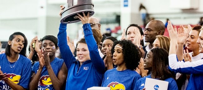 Surrounded by her Kansas University teammates, senior Andrea Geubelle hoists the second-place team trophy at the NCAA Indoor Track and Field Championships on Saturday, March 9, 2013, in Fayetteville, Ark. Geubelle won the long-jump and triple-jump individual titles, and KU placed second for the second-straight season.