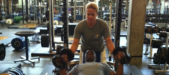 Kansas University strength-and-conditioning coach Andrea Hudy, top, works out with Sgt. Michael Pride on Wednesday during Pride’s visit to the KU campus. Pride is in town to pick up pointers from Hudy for the Wounded Warriors Project, for which he is a coach.
