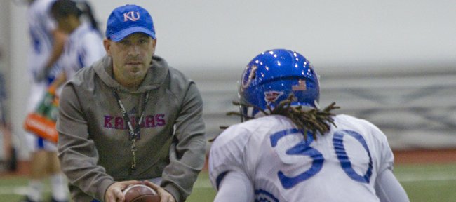 New Kansas University defensive backs coach Scott Vestal works on footwork with red-shirt freshman safety Tevin Shaw during a spring practice on March 9, 2013.