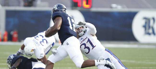 Kansas linebacker Ben Heeney reaches for Rice running back Charles Ross during the first quarter on Saturday, Sept. 14, 2013 at Rice Stadium in Houston, Texas.