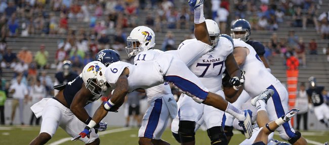 Kansas running back Darrian Miller is upended by Rice linebacker Nick Elder during the second quarter on Saturday, Sept. 14, 2013 at Rice Stadium in Houston, Texas.