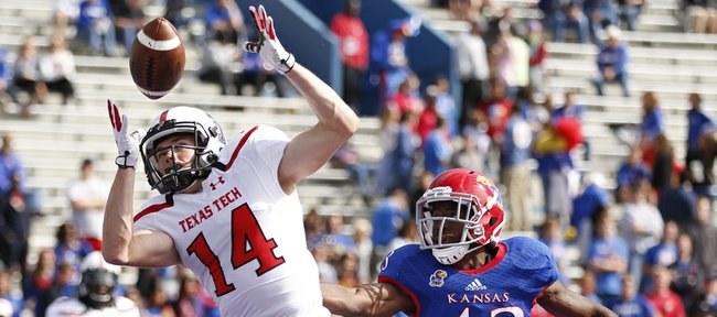 Kansas safety Alex Matlock watches as Texas Tech receiver Dylan Cantrell tips a pass to himself for the Red Raiders' final touchdown against the Jayhawks during the fourth quarter on Saturday, Oct. 5, 2013 at Memorial Stadium.