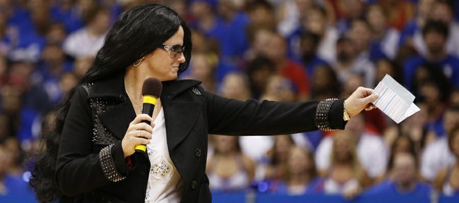 Head coach Bonnie Henrickson, dressed as Cher, points to the crowd as she heads out to the court during the skits and performance of Late Night in the Phog, Friday, Oct. 4, 2013 at Allen Fieldhouse.