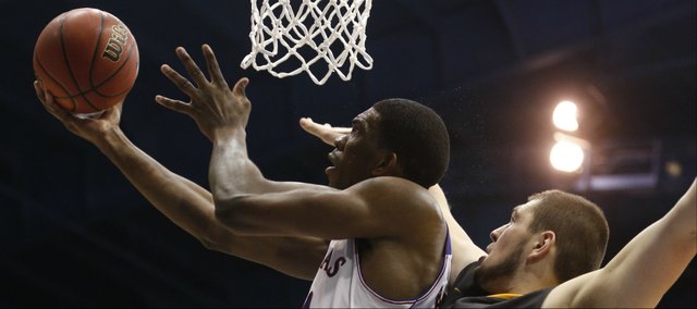 Kansas center Joel Embiid dips under the bucket for a shot against Toledo center Nathan Boothe during the second half on Monday, Dec. 30, 2013 at Allen Fieldhouse.