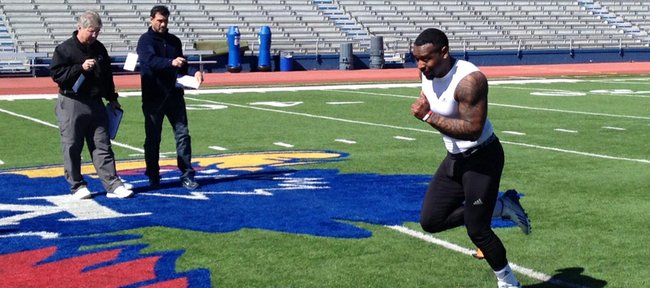 Former Kansas University running back James Sims sprints through the finish of the pro shuttle drill in front of a couple of NFL scouts on Friday at Memorial Stadium. Thirteen other former Jayhawks joined Sims at KU’s annual Pro Day on Friday, March 14, 2014, at the KU football facilities.
