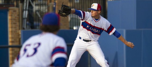 Kansas junior pitcher Wes Benjamin delivers a pitch as junior Blair Beck holds a runner near first base during Kansas' game against Oklahoma, Friday evening at Hoglund Ballpark.