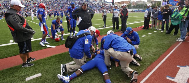 Kansas trainers attend to injured running back Tony Pierson on the sidelines. PIerson left the game during the third quarter on Saturday, Oct. 5, 2013, at Memorial Stadium.