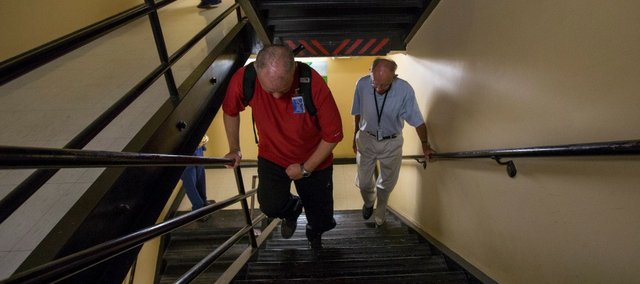 Rick McNabb, of Lawrence, left, climbs stairs at Lawrence Memorial Hospital on Friday while "coach" Jerry Waugh provides support and friendship. Four years ago, McNabb suffered an aneurysm that led to a stroke that left him paralyzed and without sensation on the left side of his body. McNabb is attempting to climb the equivalent of Mount Everest while raising money for charity. 