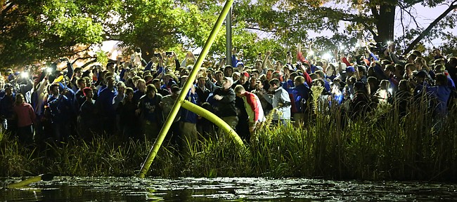 Kansas football fans toss part of an upright into Potter Lake following the Jayhawks' 34-14 win over the Cyclones on Saturday, Nov. 8, 2014.