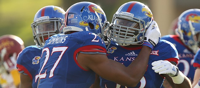 Kansas buck Victor Simmons hugs fellow buck Michael Reynolds after Reynolds forced an Iowa State fumble during the first quarter on Saturday, Nov. 8, 2014.