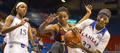 Kansas sophomore guard Keyla Morgan (32) rips a rebound away from Iona forward Joy Adams during first half action in their game Wednesday evening at Allen Fieldhouse.