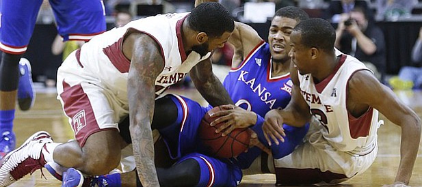 Kansas guard Frank Mason III, struggles for a turn-over during the Jayhawk's game against the Temple Owls Monday at the Wells Fargo Center in Philadelphia, PA.