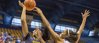 Kansas senior forward Chelsea Gardner blocks a shot by West Virginia sophomore center Lanay Montgomery during their game Saturday at Allen Fieldhouse. The Jayhawks defeated the Mountaineers, 65-59, for their second straight Big 12 win.