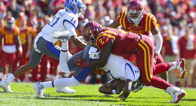 Kansas quarterback Montell Cozart (2) is dropped to the turf underneath Iowa State linebacker Jordan Harris (2) during the second quarter on Saturday, Oct. 3, 2015 at Jack Trice Stadium in Ames, Iowa.