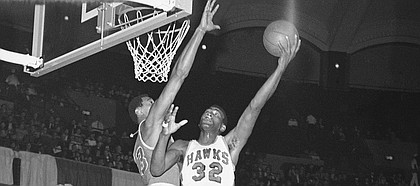 Wilt Chamberlain of the Philadelphia 76ers reaches to block the shot of Bill Bridges (32) of the St. Louis Hawks in National Basketball Assn., game in St. Louis, on Sunday, afternoon, Jan. 29, 1967.