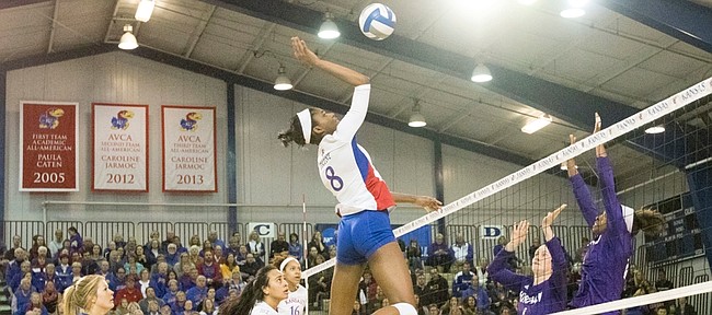 Kansas sophomore Kelsie Payne (8) goes after the ball while Furman blocker Jamila Johnson waits at the net  during the first round of the NCAA volleyball tournament Thursday evening at the Horejsi Center. The Jayhawks swept the Paladins in three sets and will face the Missouri Tigers in the second round of the tournament. The first serve is set for 6:30 p.m. at the Horejsi Center. 