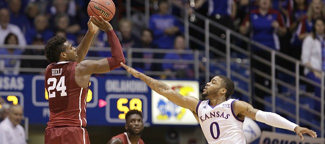 Kansas guard Frank Mason III (0) defends against a three from Oklahoma guard Buddy Hield (24) during the second half, Monday, Jan. 4, 2016 at Allen Fieldhouse.