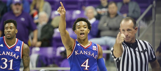 Kansas guard Devonte' Graham (4) signals with an official the ball going the Jayhawks' way after forcing a turnover by TCU guard Chauncey Collins, back, during the second half, Saturday, Feb. 6, 2016 at Schollmaier Arena in Forth Worth, Texas. At left is Kansas forward Jamari Traylor (31).