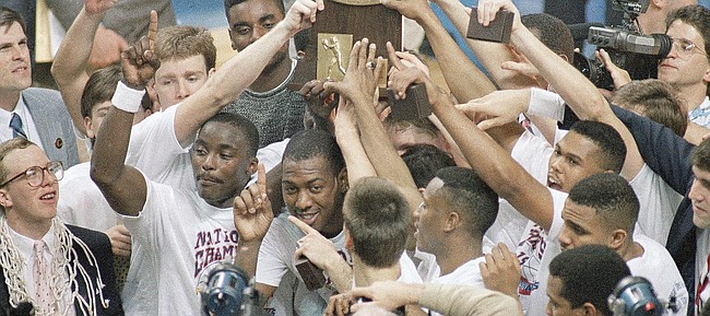 Members of the Kansas Jayhawks basketball team, including Danny Manning hold up their trophy after winning the championship game of the NCAA final four tournament in Kansas City on Monday, April 5, 1988. (AP Photo/Susan Ragan)
