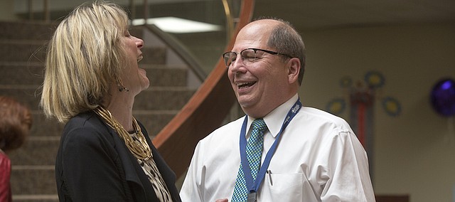 Sharon Spratt, CEO of Cottonwood Inc., left, and Gene Meyer, outgoing president and CEO of Lawrence Memorial Hospital, share a humorous moment Wednesday afternoon during Meyer's retirement reception at LMH.