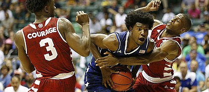 Kansas guard Josh Jackson (11) is smothered under the net by Indiana guard Josh Newkirk (2) and Indiana forward OG Anunoby (3) during the second half of the Armed Forces Classic at Stan Sheriff Center, on Friday, Nov. 11, 2016 in Honolulu, Hawaii.