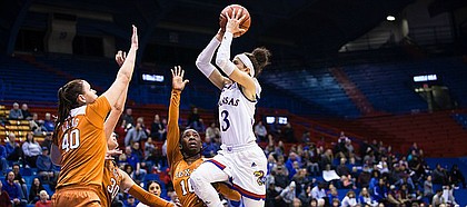 Kansas junior guard Jessica Washington (3) goes for a running jump shot over a converging group of Texas defenders, Lashaan Higgs (10), Khaleann Caron-Goudreau (30) and Kelsey Lang (40) on Wednesday at Allen Fieldhouse.