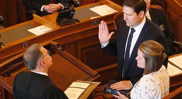In this Monday, Jan. 9, 2017, file photo, Representative Ron Ryckman (R-Olathe) is sworn in as Speaker of the House by Kansas Supreme Court Justice Lawton Nuss, in Topeka, Kan. Rickman's wife Kim is holding the bible. The Kansas House’s new speaker is receiving bipartisan praise in his first weeks in the job for what fellow lawmakers said is a collaborative style. (Bo Rader/The Wichita Eagle via AP, File)