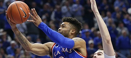 Kansas guard Frank Mason III (0) gets past Kentucky forward Isaac Humphries (15) for a bucket during the first half, Saturday, Jan. 28, 2017 at Rupp Arena in Lexington, Kentucky.
