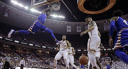 Kansas guard Lagerald Vick (2) scores over Texas guard Eric Davis Jr. (10) during the first half of an NCAA college basketball game, Saturday, Feb. 25, 2017, in Austin, Texas.