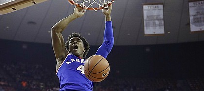 Kansas guard Devonte' Graham (4) scores over Texas guard Eric Davis Jr. (10) during the first half of an NCAA college basketball game, Saturday, Feb. 25, 2017, in Austin, Texas.