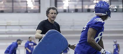 First-year Kansas offensive coordinator Doug Meacham puts KU receivers through workouts during the Jayhawks' first practice of the spring, on March 13, 2017, at Anschutz Pavilion.
