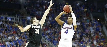 Kansas guard Devonte' Graham (4) puts up a three over Purdue guard Dakota Mathias (31) during the first half, Thursday, March 23, 2017 at Sprint Center in Kansas City, Mo.