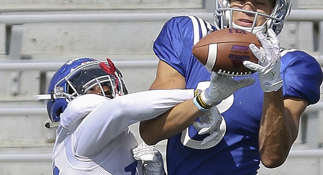 FILE — Kansas receiver Chase Harrell, right, tries to hold on to a pass as defensive back Kyle Mayberry pulls down on his arm during KU's Fan Appreciation Day practice on Saturday, August 20, 2016, at Memorial Stadium. 