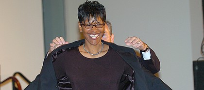 Lynette Woodard smiles as John L. Doleve, president and CEO of the Basketball Hall of Fame helps her put on her Hall of Fame jacket at a news conferernce at the Hall of Fame in Springfield, Mass., Friday, Sept. 10, 2004. Woodard is an Olympic gold medalist and the first woman to play for the Harlem Globetrotters. (AP Photo/Bob Child)