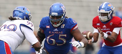 Team KU offensive lineman Jayson Rhodes (65) looks to fend off Team Jayhawk defensive tackle DeeIsaac Davis (99) during the third quarter of the 2017 Spring Game on Saturday, April 15 at Memorial Stadium.