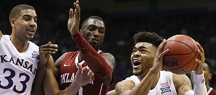 Kansas guard Frank Mason III (0) gets in for a bucket past Oklahoma forward Khadeem Lattin (12) during the second half, Monday, Feb. 27, 2017 at Allen Fieldhouse. At left is Kansas forward Landen Lucas (33).