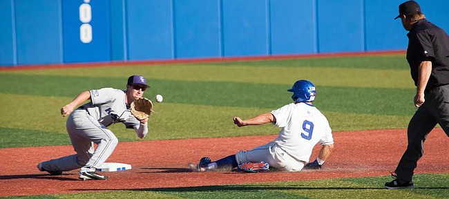 Kansas’ James Cosentino (9) slides safely into second base before Kansas State’s Jake Wodtke catches the ball during the opener of the Sunflower Showdown Friday night, May 12, 2017, at Hoglund Ballpark. 