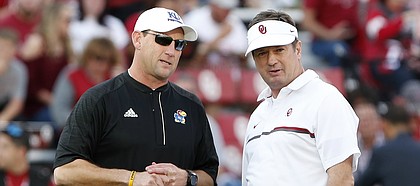 FILE — Kansas head coach David Beaty, left, and former Oklahoma head coach Bob Stoops, right, talk before the start of an NCAA college football game in Norman, Okla., Saturday, Oct.29, 2016. (AP Photo/Alonzo Adams)